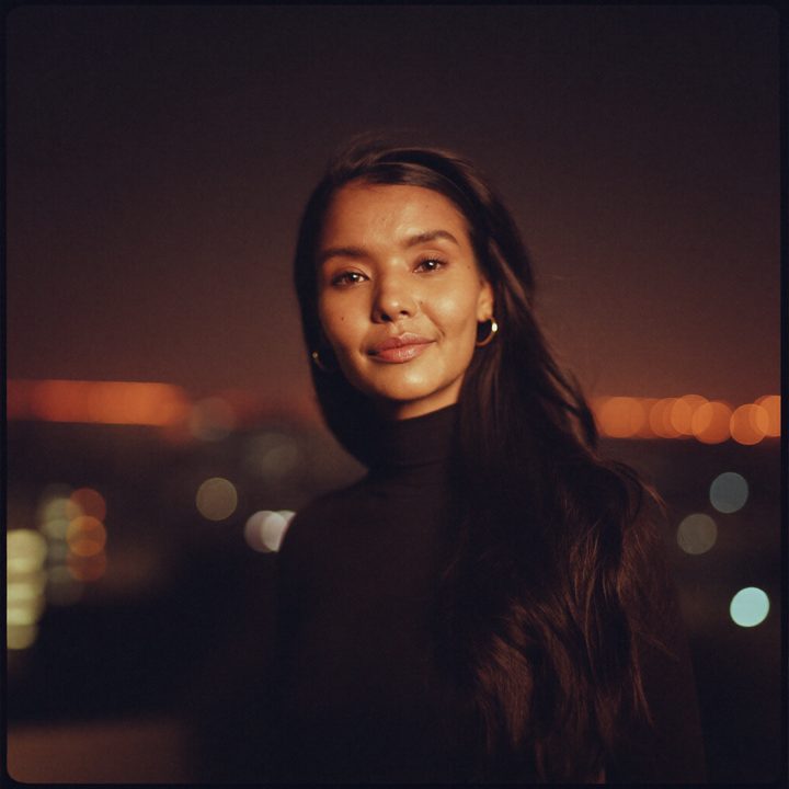 Noor on a city rooftop at night